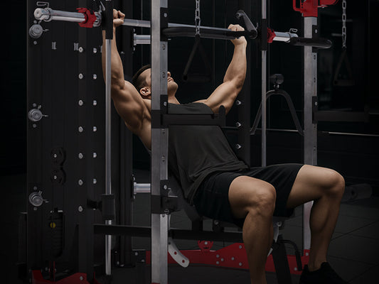 Mann beim Schrägbankdrücken an der Multipresse im Home Gym – Methode zum Überwinden von Trainingsplateaus